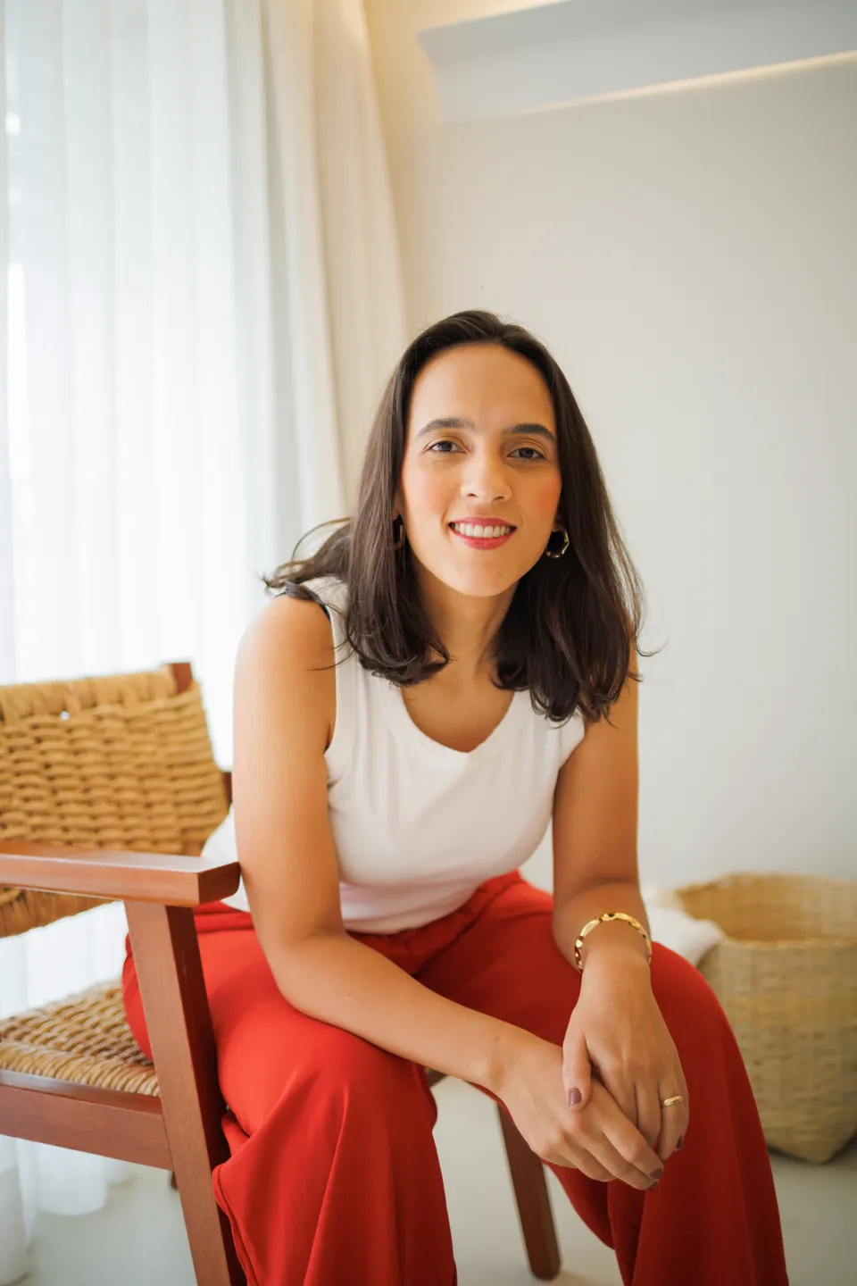 Natália Innocencio, psicóloga, sentada e sorrindo